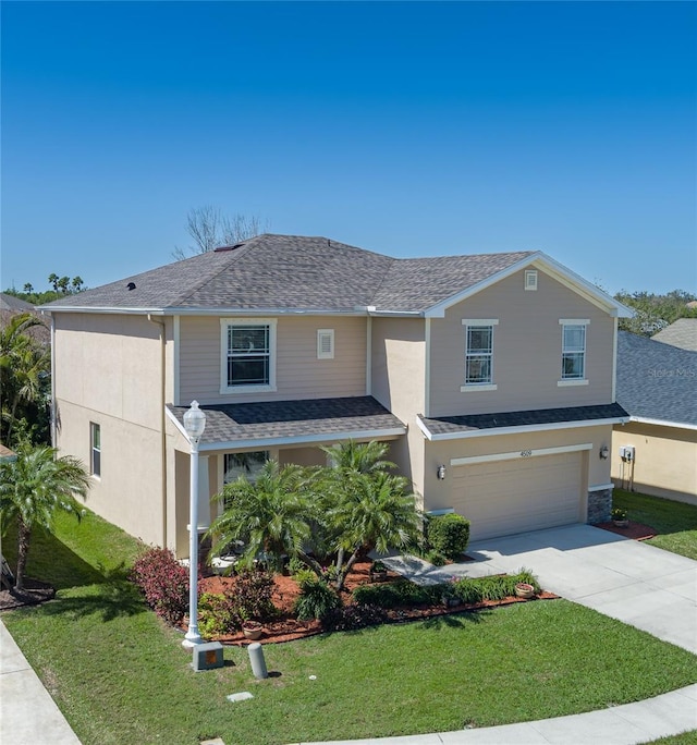 traditional-style house with driveway, roof with shingles, an attached garage, stucco siding, and a front lawn