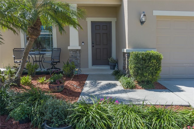 doorway to property with a garage and stucco siding