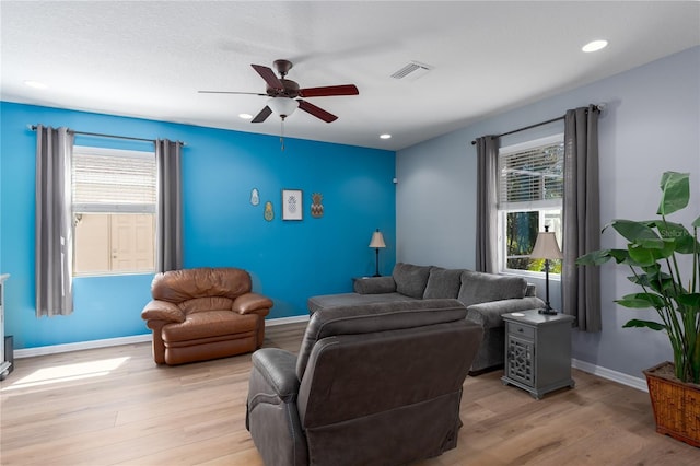 living area featuring light wood-type flooring, visible vents, baseboards, and recessed lighting