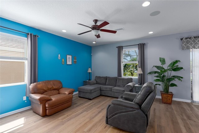 living room with baseboards, visible vents, light wood finished floors, recessed lighting, and ceiling fan