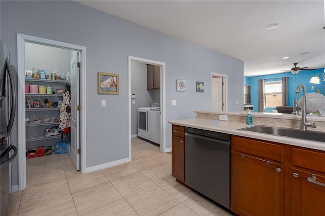 kitchen with freestanding refrigerator, a sink, light countertops, dishwasher, and washer and clothes dryer