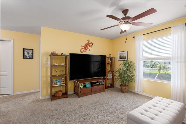 living room with baseboards, ceiling fan, and carpet flooring