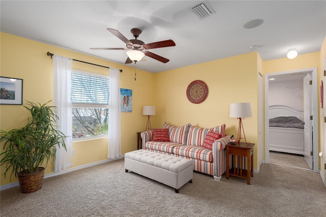 living area featuring a ceiling fan, visible vents, carpet floors, and baseboards