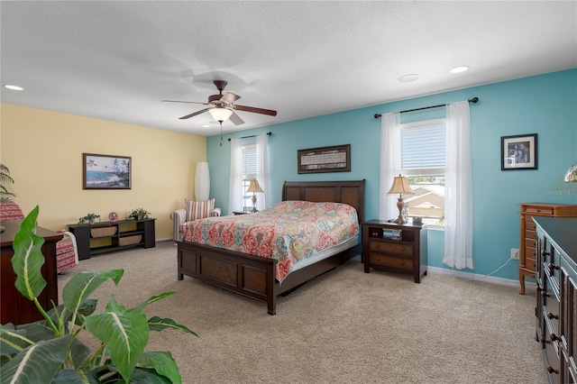 bedroom with baseboards, multiple windows, light carpet, and a ceiling fan