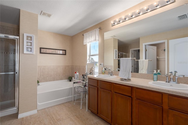 bathroom with a shower stall, double vanity, visible vents, and a sink