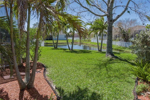 view of yard with a water view and fence