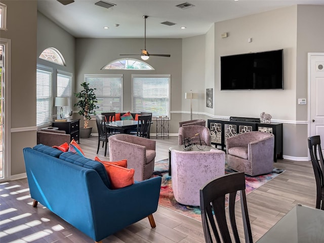 living area featuring visible vents, light wood-style flooring, a ceiling fan, recessed lighting, and baseboards