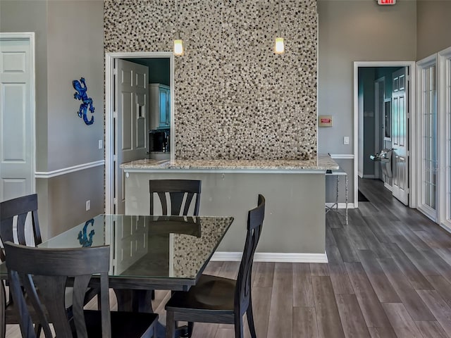 dining space featuring baseboards and dark wood-style flooring