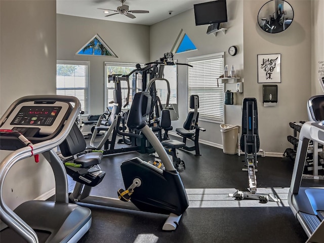 gym featuring a ceiling fan and baseboards