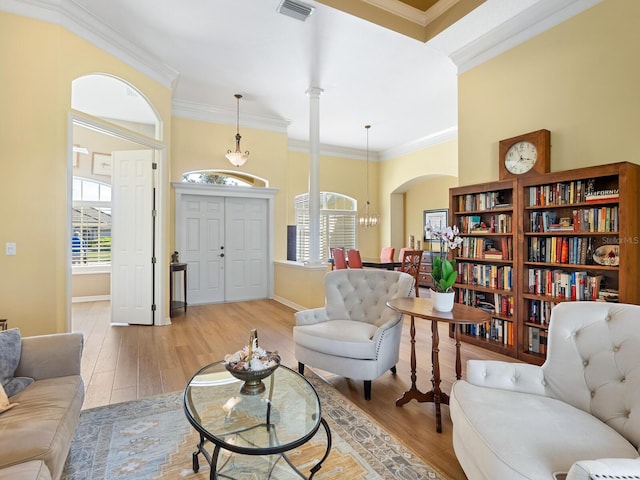 living area featuring wood finished floors, a healthy amount of sunlight, and visible vents