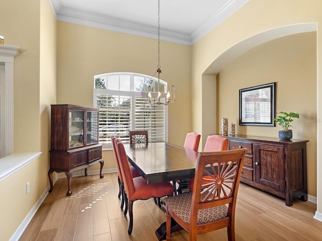 dining room with light wood finished floors, baseboards, and ornamental molding