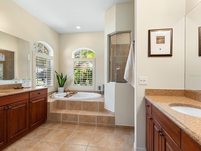 full bathroom featuring a sink, two vanities, a bath, and tile patterned flooring