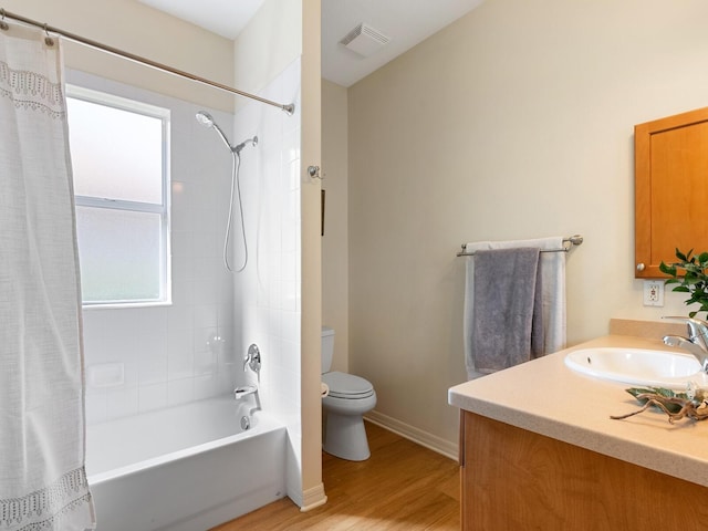 bathroom featuring visible vents, toilet, wood finished floors, vanity, and shower / bathtub combination with curtain