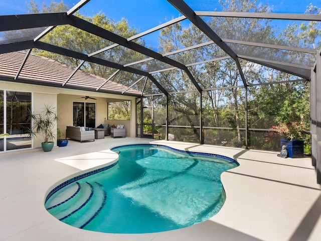 outdoor pool featuring glass enclosure, ceiling fan, outdoor lounge area, and a patio area