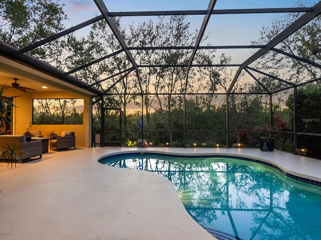 pool featuring glass enclosure, a patio, ceiling fan, and an outdoor hangout area