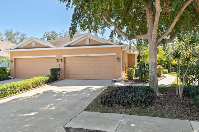 view of front facade with an attached garage, concrete driveway, and stucco siding