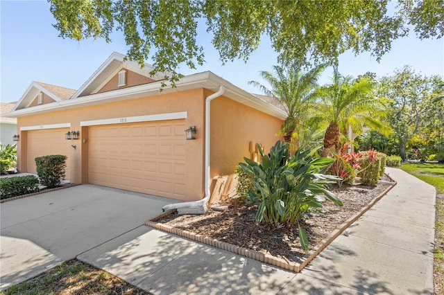 view of front of home featuring a garage, concrete driveway, and stucco siding