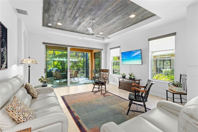 tiled living room featuring a healthy amount of sunlight, wooden ceiling, visible vents, and a tray ceiling