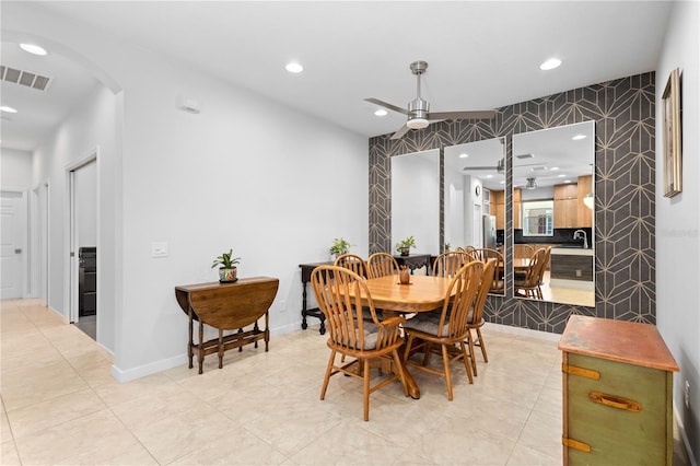 dining space featuring arched walkways, visible vents, baseboards, and recessed lighting