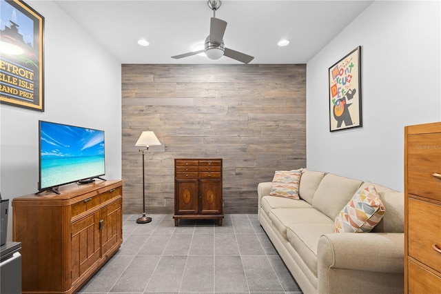 tiled living area featuring wood walls, a ceiling fan, and recessed lighting