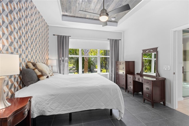 bedroom with wood ceiling, ceiling fan, a tray ceiling, and tile patterned floors