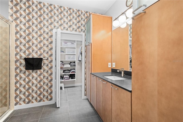 bathroom featuring a shower stall, vanity, a walk in closet, and tile patterned floors