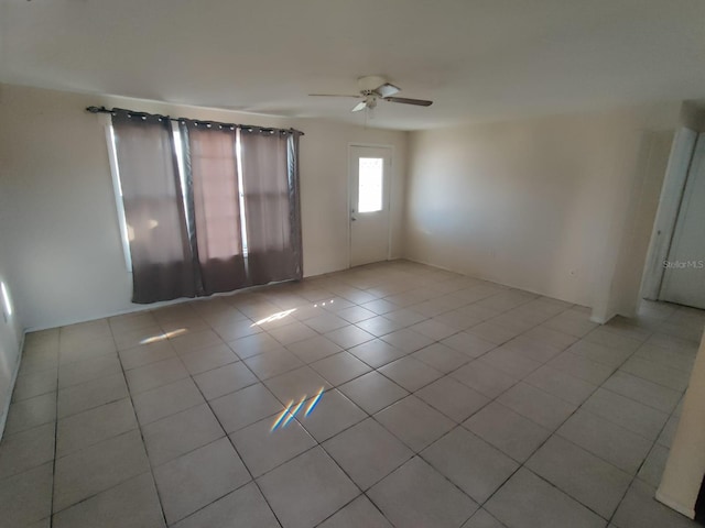 empty room with light tile patterned flooring and ceiling fan