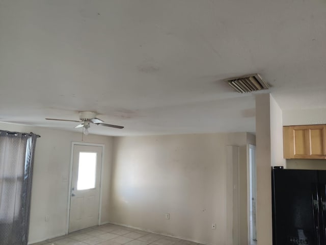 unfurnished room with ceiling fan, visible vents, and light tile patterned flooring