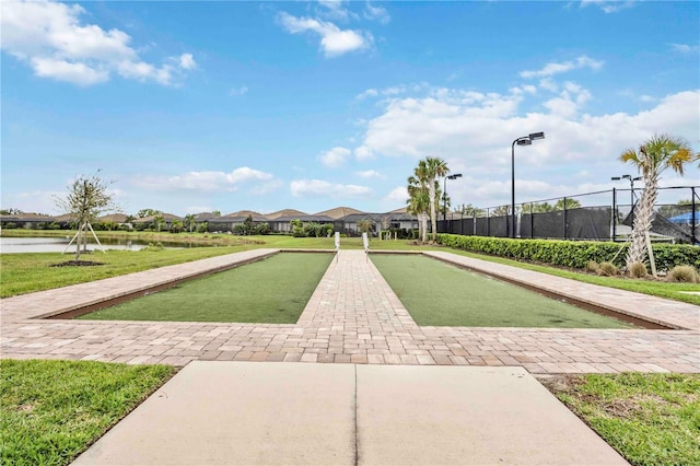 view of property's community with a water view and fence