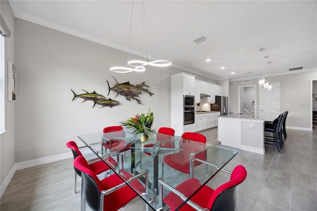 dining room with baseboards, visible vents, a chandelier, and ornamental molding