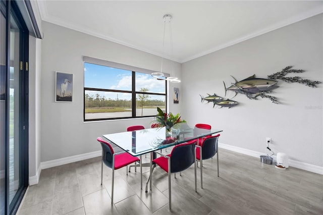 dining space featuring light wood finished floors, baseboards, and crown molding