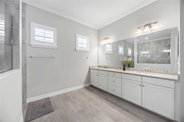 full bathroom with double vanity, walk in shower, a sink, and crown molding