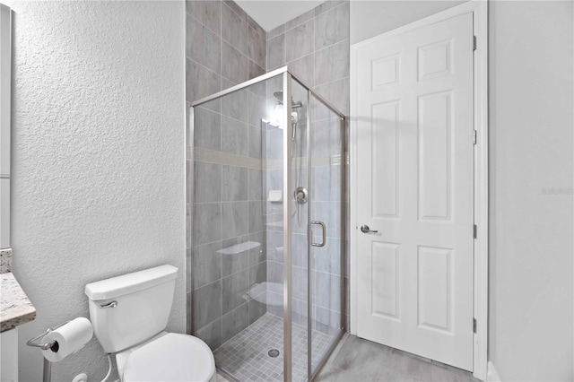 full bath with toilet, a stall shower, and a textured wall