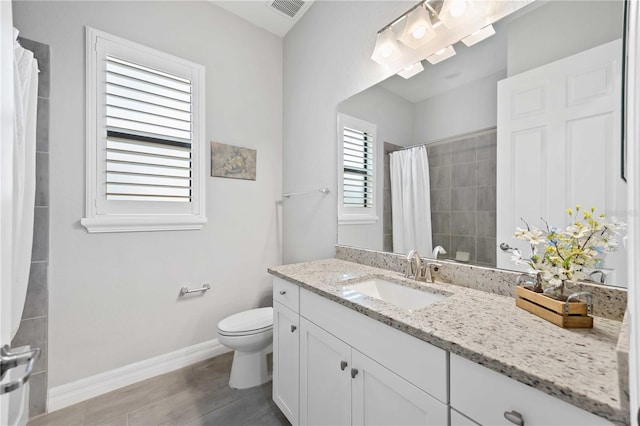 bathroom featuring visible vents, baseboards, toilet, curtained shower, and vanity