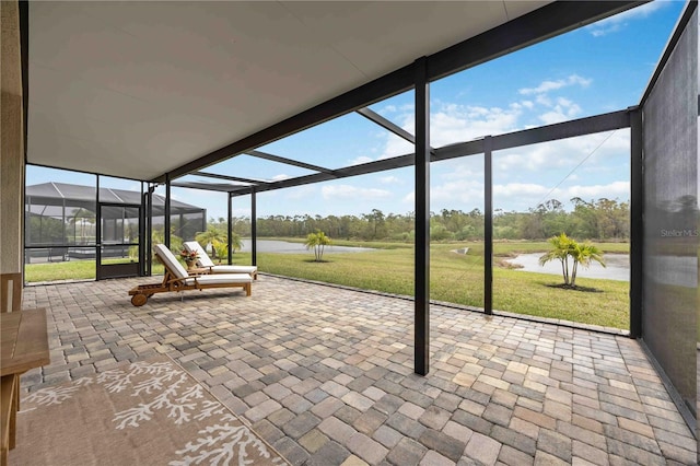 unfurnished sunroom featuring plenty of natural light and a water view