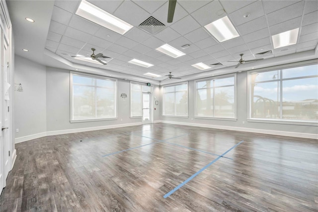 empty room featuring visible vents, plenty of natural light, and wood finished floors