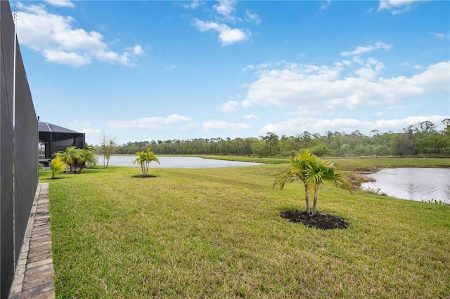 view of yard with a water view and glass enclosure