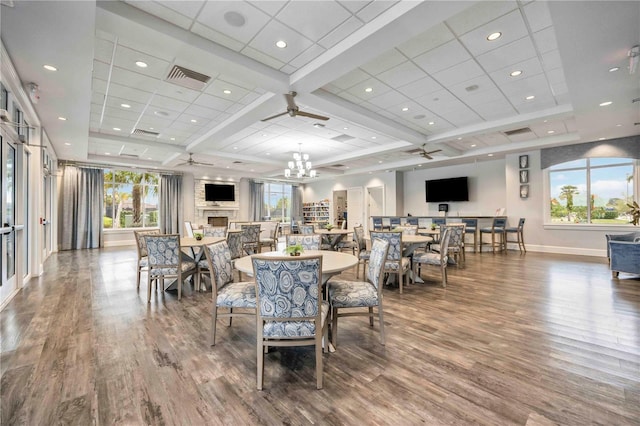 dining area featuring a fireplace, wood finished floors, visible vents, and baseboards