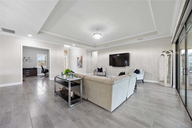 living room featuring a tray ceiling, ornamental molding, a desk, baseboards, and recessed lighting