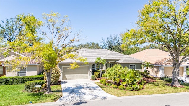 view of front of house featuring driveway, a tile roof, an attached garage, a front lawn, and stucco siding