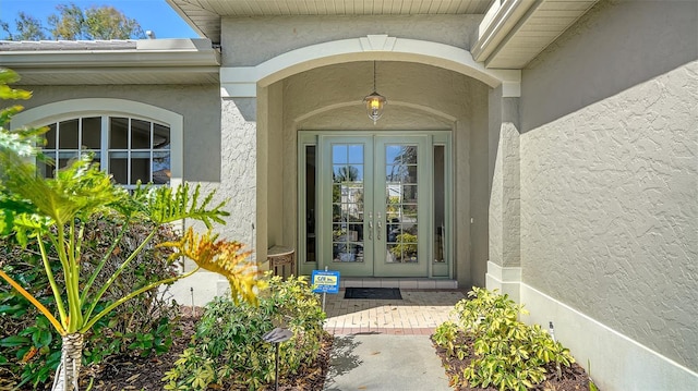 view of exterior entry with french doors and stucco siding