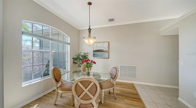 dining room with ornamental molding, a healthy amount of sunlight, visible vents, and baseboards