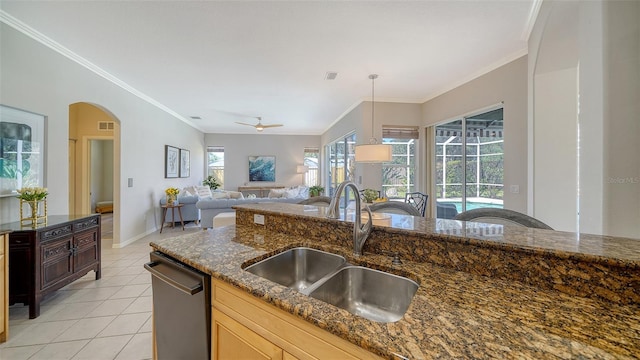 kitchen featuring ornamental molding, a sink, stainless steel dishwasher, and light tile patterned floors