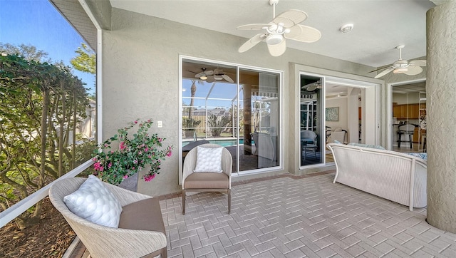 sunroom / solarium featuring a ceiling fan