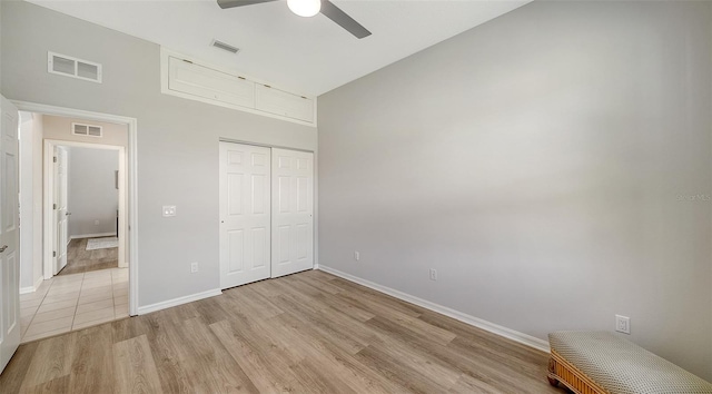 unfurnished bedroom featuring light wood-style floors, a closet, and visible vents