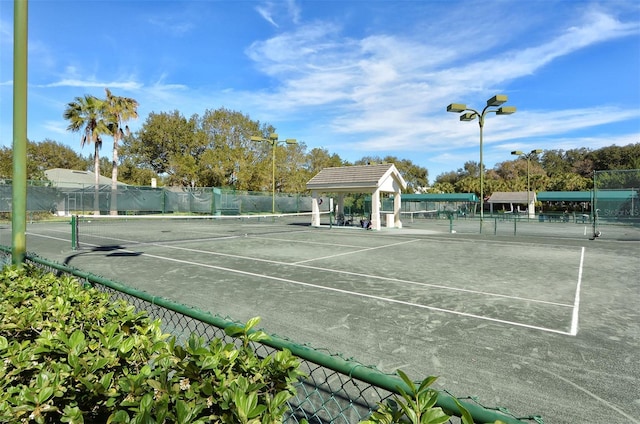 view of tennis court featuring fence