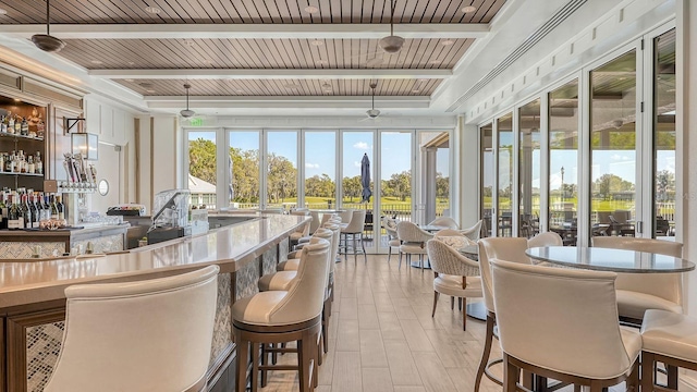 sunroom / solarium with wood ceiling, a dry bar, and beam ceiling