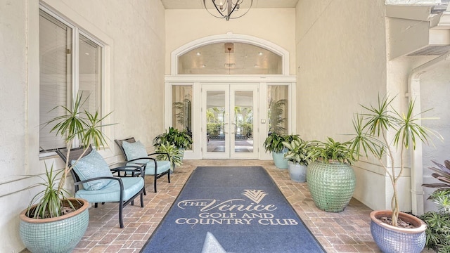 view of exterior entry with stucco siding and french doors