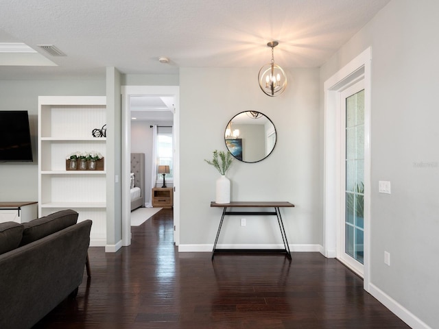 foyer entrance featuring visible vents, baseboards, and wood finished floors