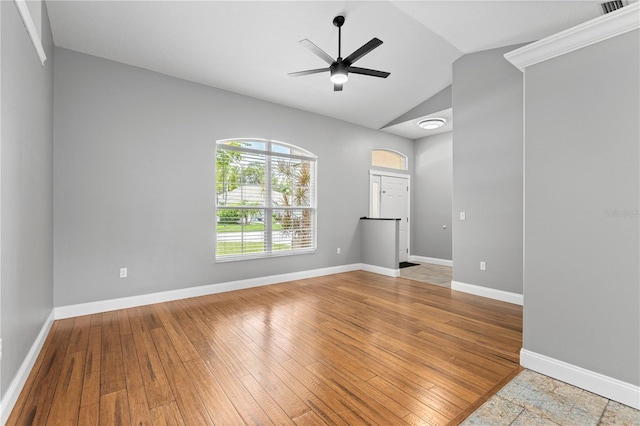 empty room featuring a ceiling fan, lofted ceiling, baseboards, and hardwood / wood-style floors